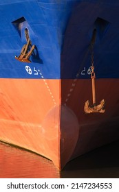 Front view of bow of cargo ship. Close up of vessel bow with anchors and draft mark. Marine background.