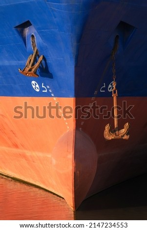 Front view of bow of cargo ship. Close up of vessel bow with anchors and draft mark. Marine background.