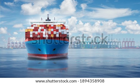 Front view from bow of a large blue shipping container ship on a background with container terminal.