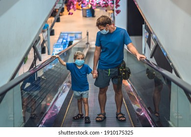 Front View Boy, Father Going Up Escalator In Super Market Wear Face Protect Mask, COVID Coronavirus Pandemic Lockdown Quarantine. Dad Hold Child Hand, Look At Kid. New Life Reality, Family Shopping