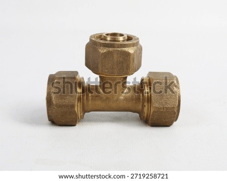 Front view of a brass tee pipe connector with compression nuts, isolated on white background. Durable metal fitting for plumbing and water distribution systems.