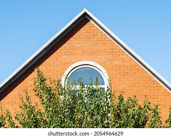 front view of brick gable wall of country house and blue sky on sunny day