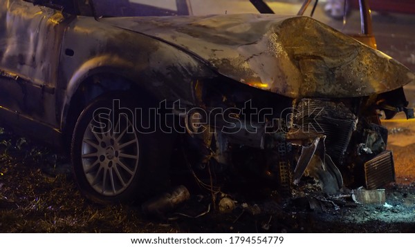 Front view of the car burned\
after the serious car accident at night in winter. High quality\
photo