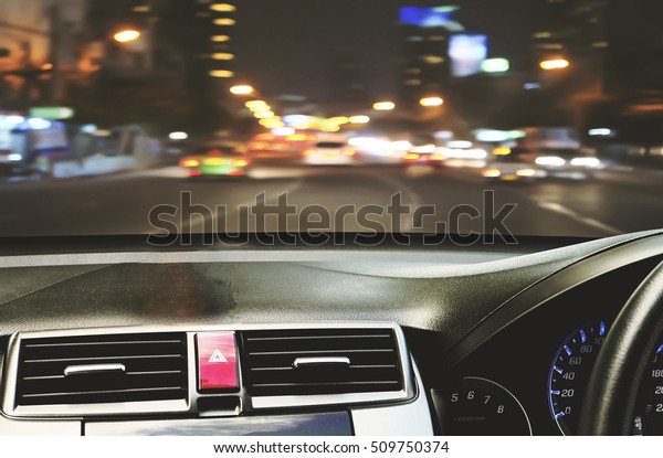 Front view of car looking out from inside with\
twilight road background