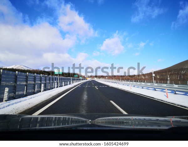 Front view from\
car on highway on blue sky\
day