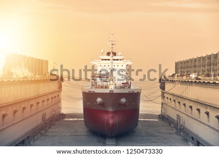 Front View cargo ship moored at floating dry dock under repair maintenance in shipyard, on sepia tone
