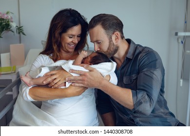 Front View Of Caucasian Couple Holding Their Newborn Baby In The Ward At Hospital