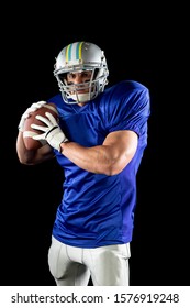 Front View Of A Caucasian Male American Football Player Wearing A Team Uniform, Pads And A Helmet, With Eye Black Under His Eyes, Preparing To Throw The Ball. Vertical Shot