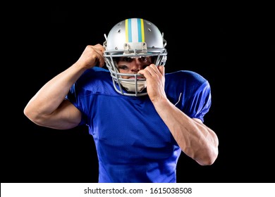 Front View Of A Caucasian Male American Football Player Wearing A Team Uniform And Pads, Putting On His Helmet On Black Background