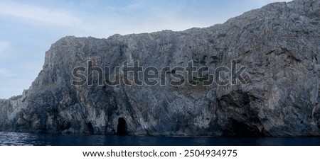 Front view of cliffs on the southern coast of Sardinia island, Italy, near Masua, seen from a boat. Summer beach travel concept