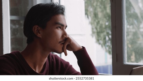 Front view close up of biracial man with short dark hair, working at home, sitting at the table in his sitting room, using laptop computer. - Powered by Shutterstock