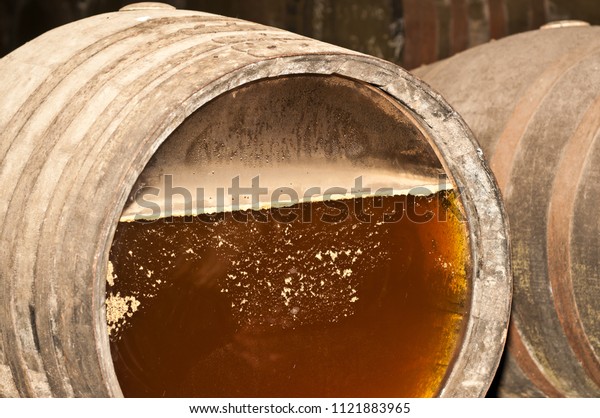 Front\
view, close up of a wine barrel top,  with glass insert, showing\
the aging fermentation process of sherry, in a three generation\
wine cellar, in the southeastern region of\
Spain