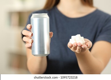 Front View Close Up Of A Woman Hands Holding A Soda Drink Can And Sugar Cubes At Home