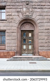 front view of closed entrance to old apartment house tiled with granite tiles with soviet symbols in Moscow city