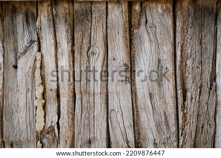 front view closeup of rustic weathered brown barn wood background with knots and nail holes