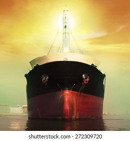 front view of commercial ship floating in port against sun light over sky