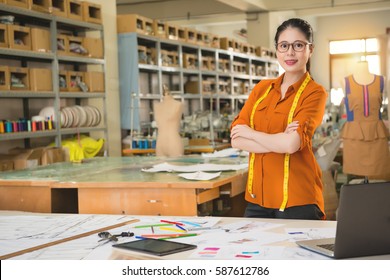 Front View Of Confident Successful Fashion Chinese Woman Designer Cross Arm Standing In Manufacturing Office Studio. Profession And Job Occupation Concept.