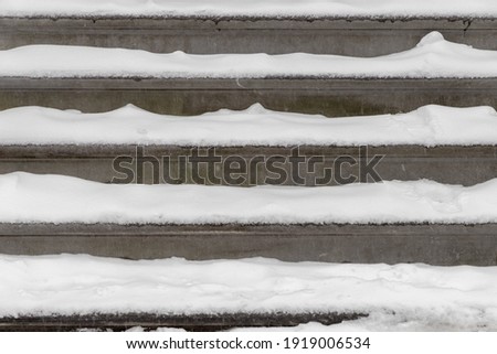 Front view of construction grey gravel concrete stairs covered with white snow in winter, Outdoor granite stair includes steps, Rough cement texture, Surface stone background.