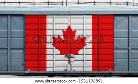 Front view of a container train freight car with a large metal lock with the national flag of Canada.The concept of export-import,transportation, national delivery of goods and rail transportation