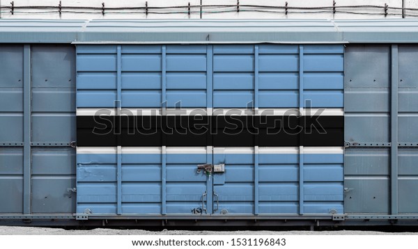 Front view of a container train freight\
car with a large metal lock with the national flag of Botswana.The\
concept of export-import,transportation, national delivery of goods\
and rail transportation