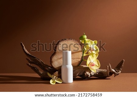 Front view of cosmetic jar decorated with branch tree and flower in brown background 