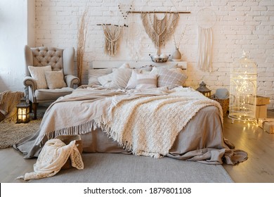 Front view of cozy bedroom with soft plaid and warmth blanket on comfortable bed, pillows, cushions, armchair, home decor and interior design in bohemian style - Powered by Shutterstock