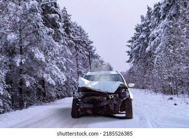 Front View Of A Crashed Car Wreck In Winter Forest Background On A Snowy Slippery Road