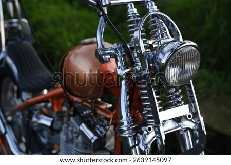 Front View of Custom Chrome Chopper with Headlight, Springs, and Red Fuel Tank