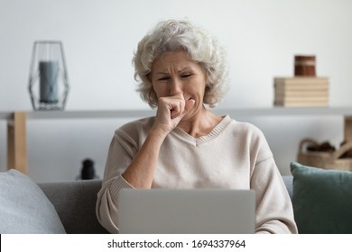 Front View Depressed Senior Older Woman Crying, Looking At Computer Screen. Stressed Worried Middle Aged Mature Grandmother Grieving, Received Bad Message Notification, Sitting Alone At Home.