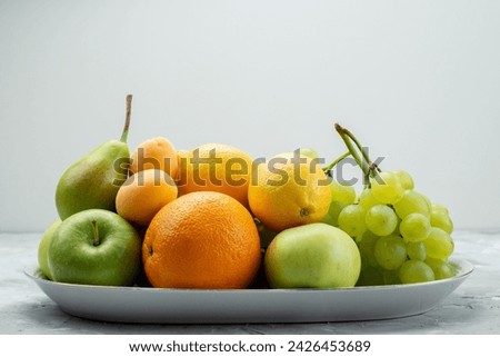 a front view different fruits such as lemons pears apples grapes and oranges on the white desk inside plate fruit color vitamine summer fresh