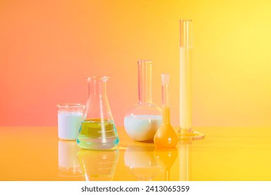 Front view of different types of laboratory glassware filled with colorful liquid decorated over gradient yellow and pink background. Laboratory experience and research concept - Powered by Shutterstock