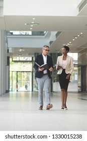 Front View Of Diverse Business People Interacting With Each Other While Walking In Lobby Office