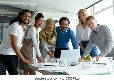 Front View Of Diverse Business People Looking At Camera While Working Together At Conference Room In A Modern Office