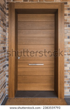 Front view of front door of a house in solid wood and brick wall. Security concept