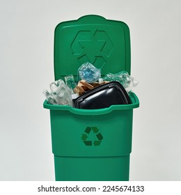 Front view of dustbin full of unsorted garbage. Ecology safety. Waste disposal and recycling. Environmental sustainability. Isolated on white background. Studio shoot
