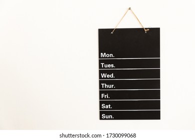 Front View Of Empty Weekly To Do List White Grid Timetable Schedule On Black Chalkboard Hanging On The Wall