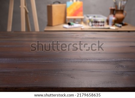 Front view of empty wood table and artist tools. Paintbrush and art painter supplies on desk background texture. Painting in artist workplace