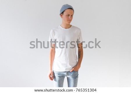 Front view or face side of young hipster millennial man, skinny and fit with arm tattoos, natural handsome beauty in white simple mockup tshirt from organic cotton 