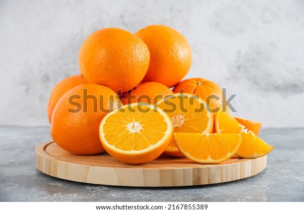 front view fresh\
sliced orange on dark background ripe mellow fruit juice color\
citrus tree citrus, Whole and sliced ripe oranges placed on marble\
background, half orange\
fruit.