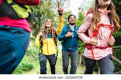 Front view of friends group trekking in forest on italian alps - Hikers with backpacks walking around wild mountain woods - Wanderlust travel concept with young people at excursion - Warm vivid filter - Powered by Shutterstock