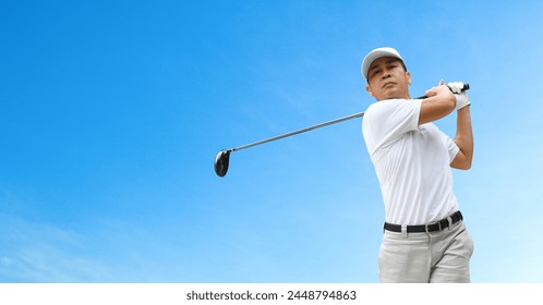 Front view of Golfer hit sweeping driver after hitting golf ball with blue sky background. - Powered by Shutterstock