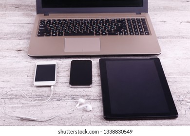 Front view, gray background, two mobile phones, a laptop and a tablet. - Shutterstock ID 1338830549