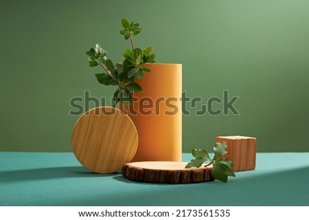 Front view of green leaf decorated with wooden cube in green background