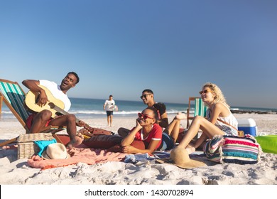 Front view of group of happy diverse friends having fun together on the beach - Powered by Shutterstock