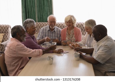 Front view of group of senior people playing cards in living room at nursing home - Powered by Shutterstock