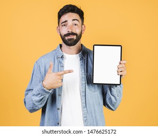 Front view guy pointing at a tablet - Shutterstock ID 1476625172