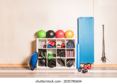 Front View Of Gym Equipment Arranged On Shelves On Wall