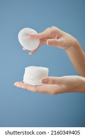 Front View Of Hand Model Holding Cotton Pad In Blue Background For Cosmetic Advertising