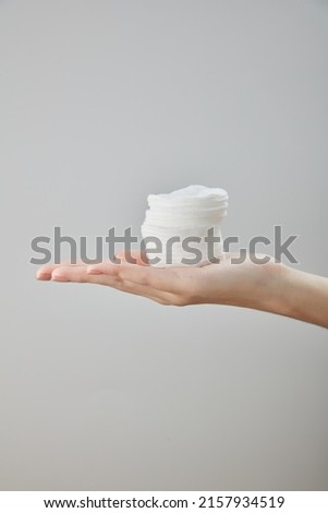 Front view of hand using cotton pad on white background 