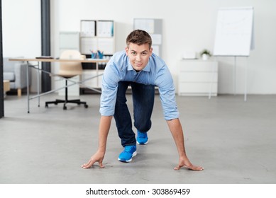 Front View of a Handsome Young Office Man in a Race Starting Position on the Floor, Looking at the Camera - Powered by Shutterstock